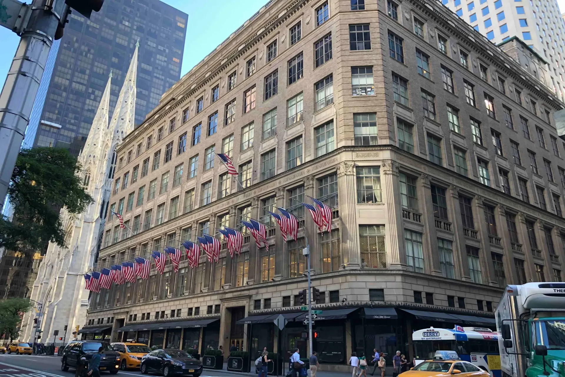Saks Fifth Avenues facade med rækken af amerikanske flag og St. Patrick's Cathedral i baggrunden