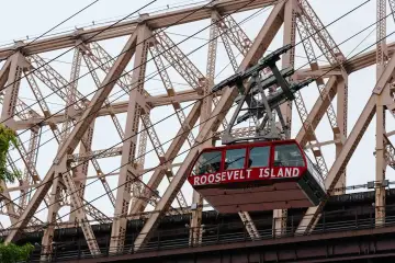 Den røde kabine fra Roosevelt Island Tramway på vej over East River langs Queensboro Bridge